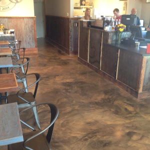 Metallic Marble Epoxy Restaurant Flooring with a high-gloss finish and a marbled pattern in shades of gray and white. The flooring has a reflective quality that gives it a modern and luxurious appearance.